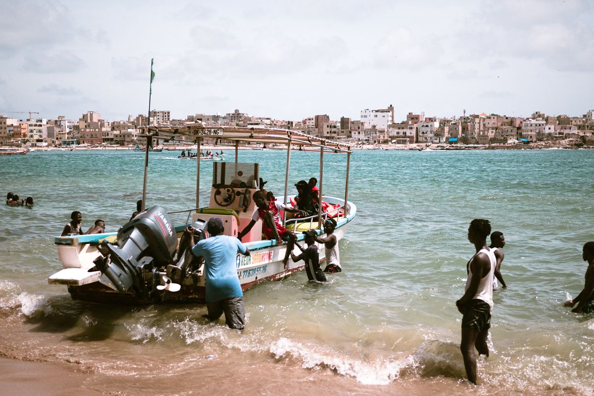 Des pêcheurs ramènent une pirogue sur une plage du Sénégal